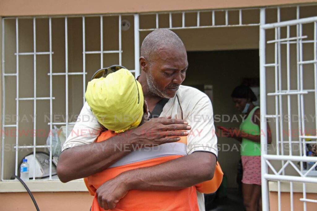 Wilfred Chattagoon is comforted with a hug at Sacred Hearts Villa on Monday. The 40-year-old Gasparillo man’s family perished on Saturday in a fire that destroyed his home. - Marvin Hamilton