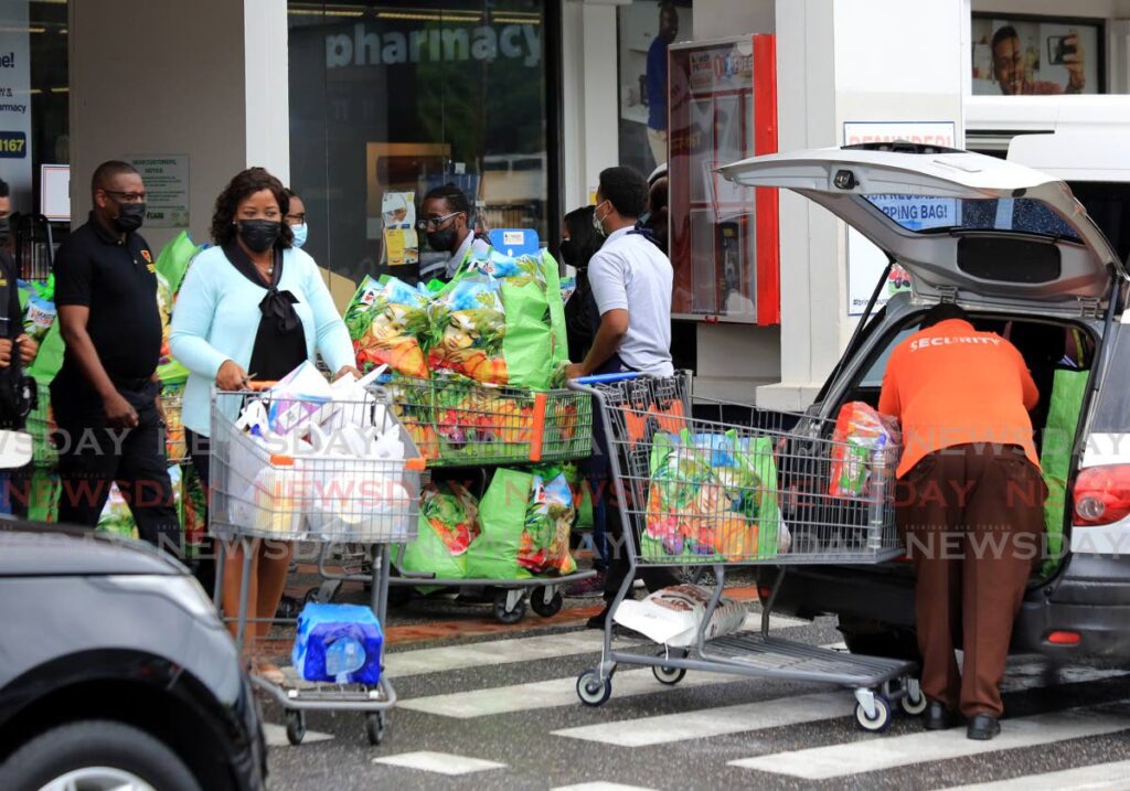 People stocking up on groceries before at Massy Stores, Westmoorings. - Sureash Cholai