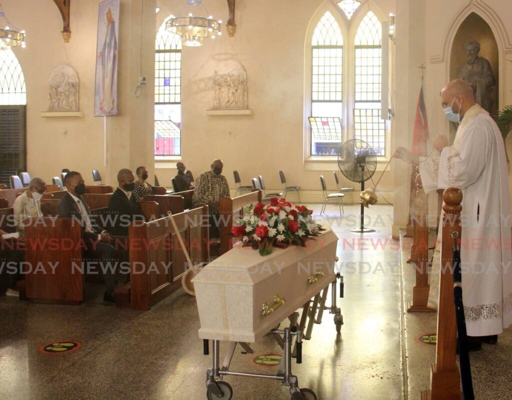 Fr. Matthew d'Hereaux swings incense over the coffin of Keon Chow Cop during his funeral at the Cathedral of the Immaculate Conception, Independence Square, Port of Spain. - AYANNA KINSALE