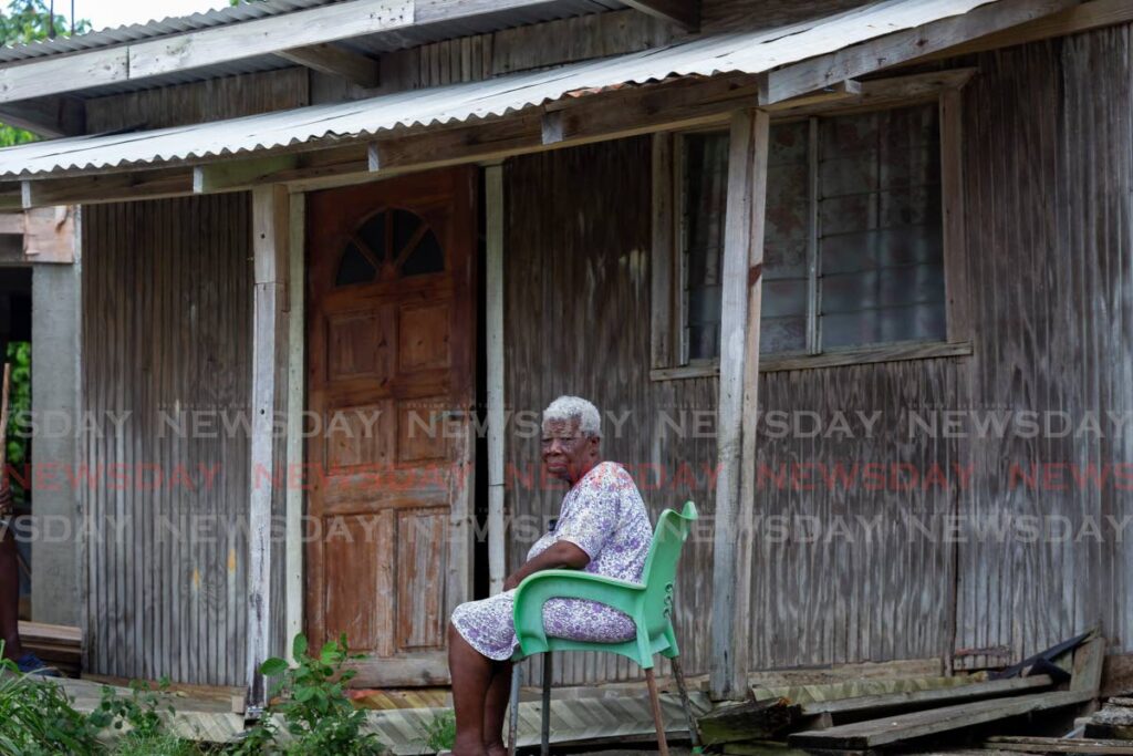 Bethany resident Marjorie Taylor looks forlorn outside her wooden home which was badly damaged on Wednesday morning by strong winds which accompanied the tropical wave. - David Reid