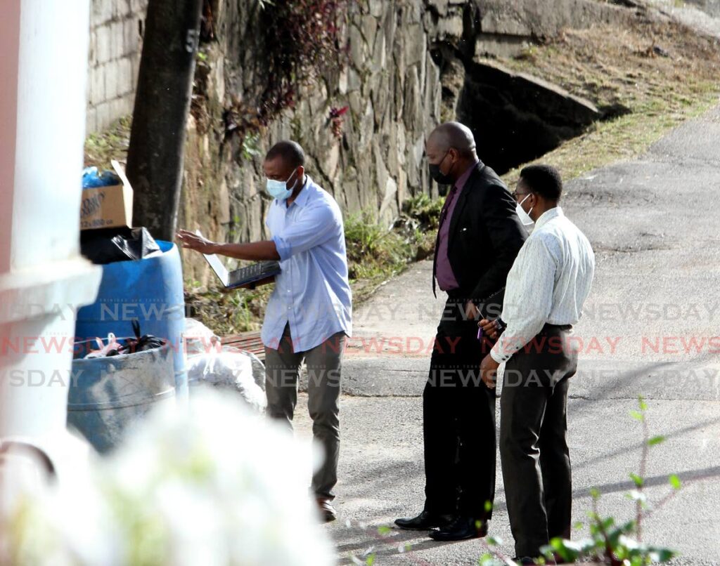 Director of Public Prosecutions Roger Gaspard SC, centre, with lead investigator Supt Wayne Abbott, right, and another officer at the scene where three men were killed by police in Morvant in August last year.  - Angelo Marcelle