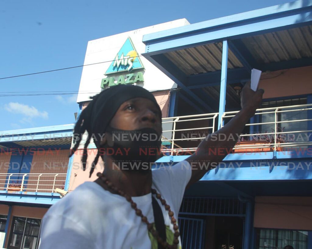 In this file photo an MTS employee takes part in a protest outside the National Maintenance Training and Security Ltd head office in Aranguez. - 