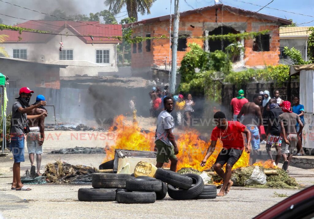 In this file photo, a group of young men set fire to debris on Production Drive, Sea Lots on July 4, to protest against the police killing of two teenagers and another young man by police on July 2 in Port of Spain.  - ROGER JACOB