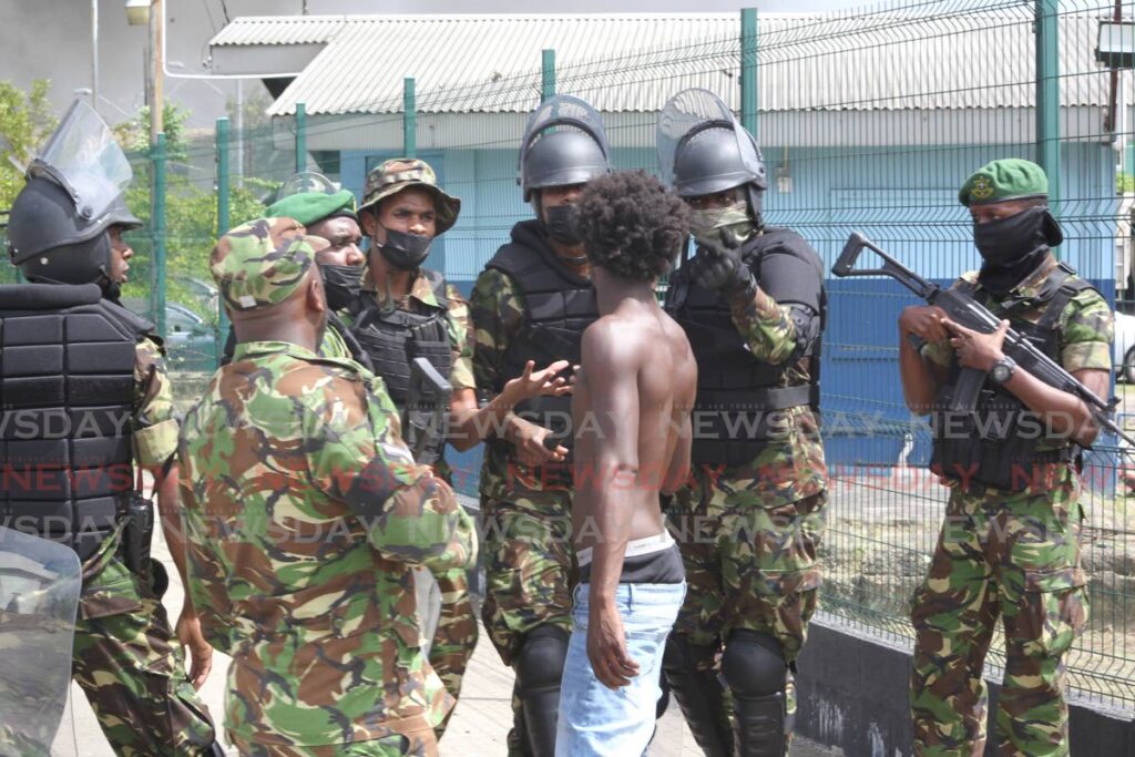 Soldiers restore order in Beetham Gardens, Port of Spain on July 4, after a violent protest by residents over the police killing of three young men two days earlier.  - ROGER JACOB