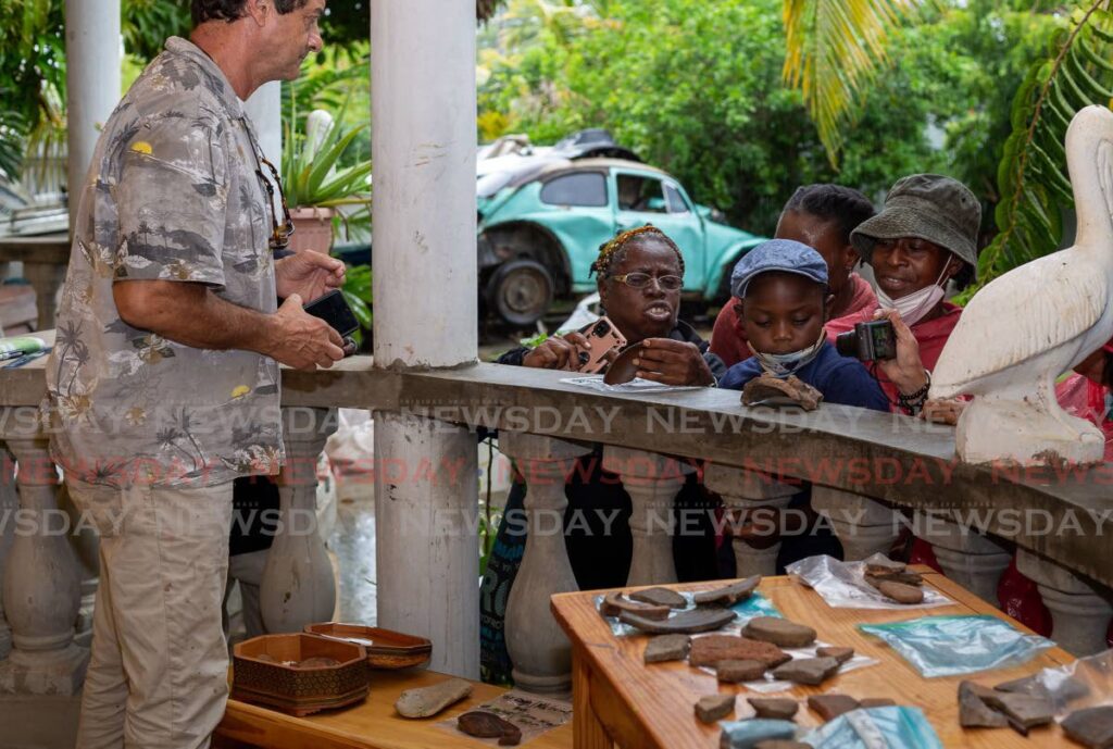 Members of the public observe artifacts, from 3500 BC to 1500 AD, at Cove estate, Tobago, Tuesday. The artifacts were found by Armagh Majias and Dale Grant in the Mt Irvine area. - David Reid