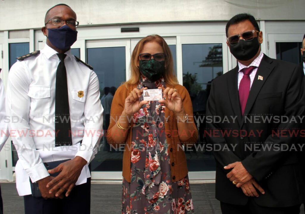 Rajie Ramsingh, who was the first person to get the new drivers' licence on Friday, is flanked by Transport Commissioner Clive Clarke and Works and Transport Minister Rohan Sinanan at the Caroni licensing office during the launch. - AYANNA KINSALE