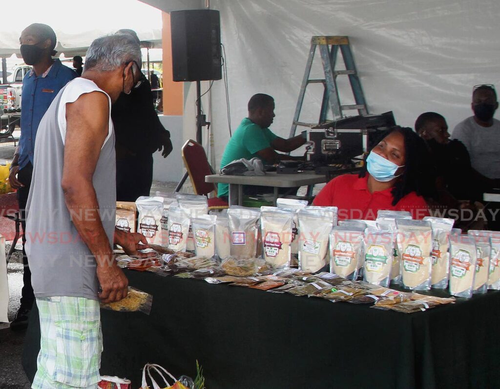 Akeila Dalrymple, of Heaven Bliss, chats with a customer about alternative flour products at the Chaguanas Farmers Wholesale Market, Chaguanas on Saturday. - ROGER JACOB