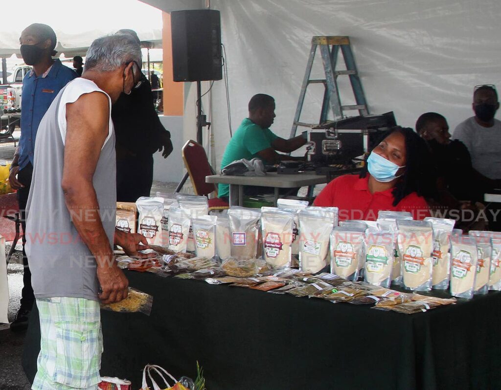 Heavenly Bliss owner Akeila Dalrymple chats with a customer about alternative flour products at the Namdevco Farmers Market, held at Endeavour Road, Chaguanas, on July 9. - ROGER JACOB