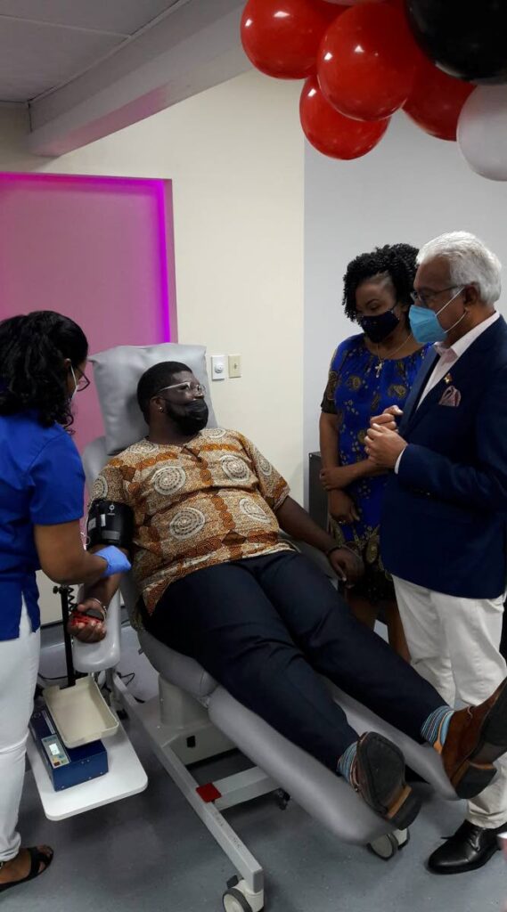 Health Minister Terrence Deyalsingh and Education Minister Dr Nyan Gadsby-Dolly speak with president of the UWI Guild of Students Kobe Sandy as he donates blood at the rebranded blood donation centre at the Eric Williams Medical Sciences Complex, Mt Hope on Sunday. Photo courtesy the Ministry of Health 