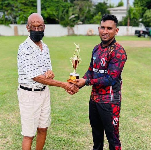 Tobago sports administrator Bertille St Clair, left, presents Trinidad’s Adrian Ali with the Player of the Match award for his knock of 99 against Tobago Marlins at Shaw Park on Sunday.  - TTCB
