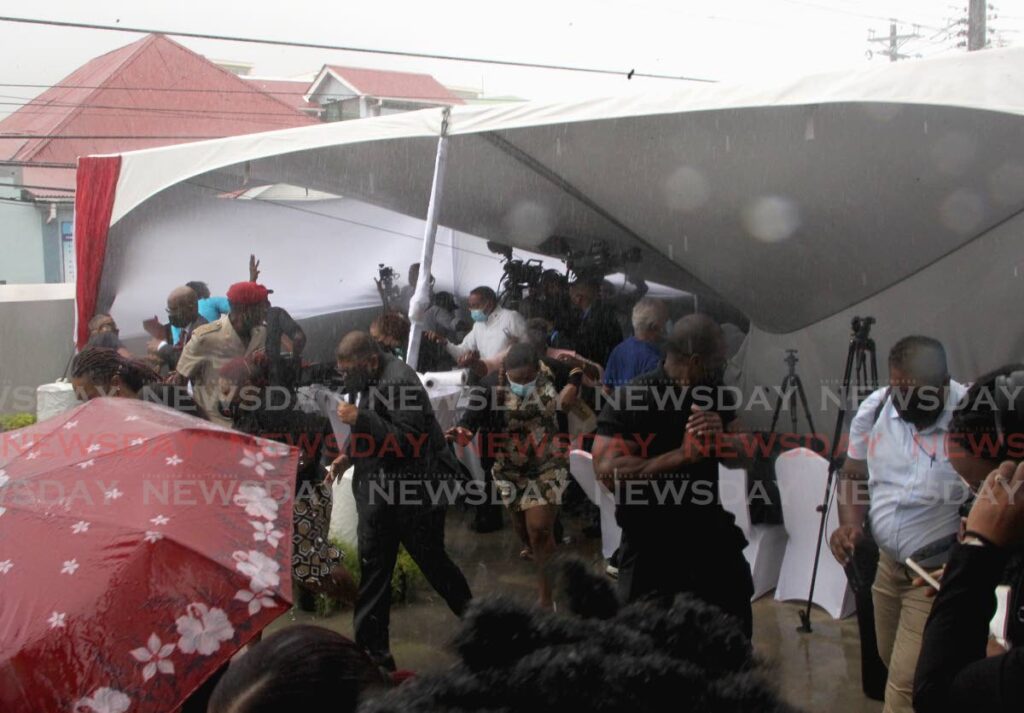 Guests, media and government officals scatter as a tent collapses at the re-opening of the Jennifer Shaw Transitional Home for Young Women, Henry Street, Port of Spain on Tuesday. - ROGER JACOB