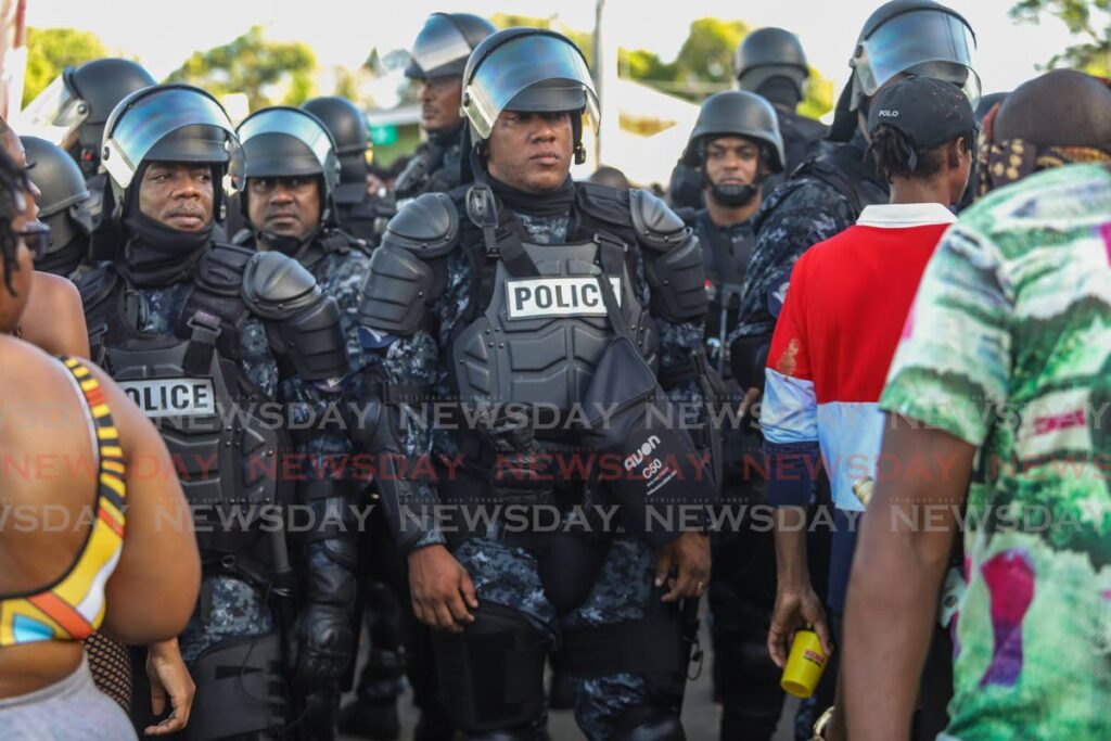 Cops in riot gear move through the crowd at Plymouth J'Ouvert celebrations during Tobago Heritage Festival, Saturday. - 