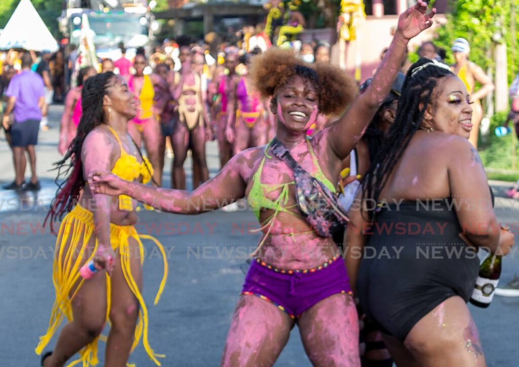 Costumed masqueraders enjoy themselves during the J'Ouvert celebrations at Plymouth, Tobago on July 23.  - David Reid