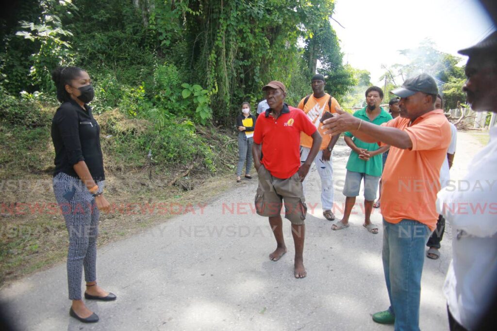 Moruga Tableland MP, Michelle Benjamin listen to angry residents  who blocked the La Lune main road, Moruga on Monday in protest to highlight the bad roads and poor drainage in the area. Photo by Lincoln Holder