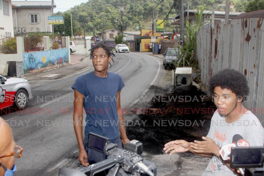 HEAR ME SPEAK: Maraval residents Aaron Antoine, centre, and John Romany speak with reporters on Monday about the fiery protests in Maraval. Photo by Roger Jacob