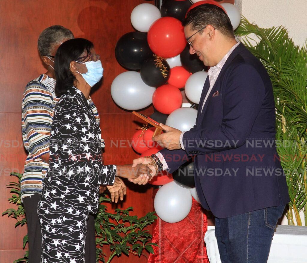 First-time visually impaired author Sharon Joseph receives a plaque from Minister of Communications in the Office of the Prime Minister Symon de Nobriga, at the 13th annual 1st time authors' appreciation programme, at the University of Trinidad and Tobago Academy of the Performing Arts, NAPA, Port of Spain on Tuesday.  Photo by Angelo Marcelle