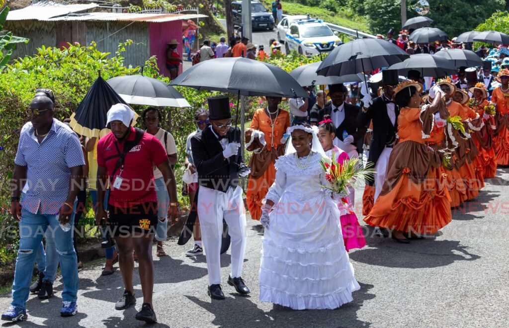 The bride and groom leads the wedding processing through the streets of Moriah, Tobago on Saturday. - David Reid