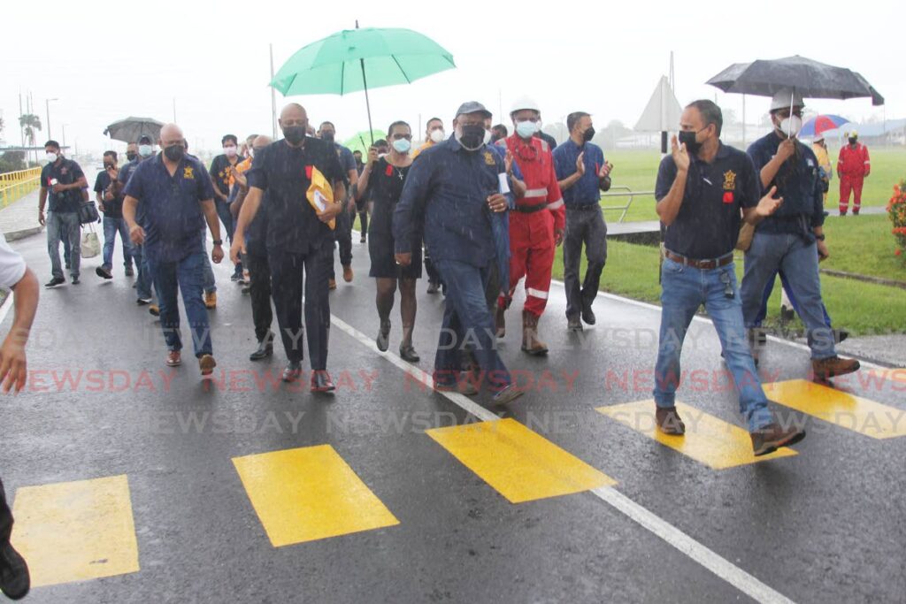 Yara workers walk through the rain with their union representatives, led by OWTU president general Ancel Roget, as they make their way to deliver a letter to management highlighting concerns about stalled negotiations. Photo by Lincoln Holder