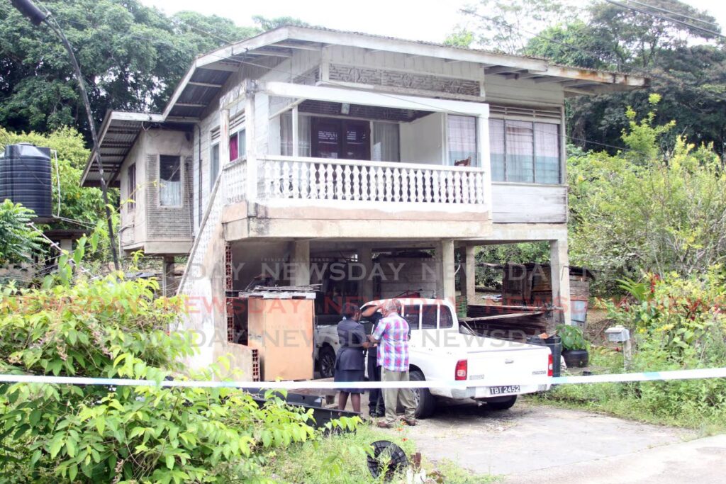 File photo: Police officers at the home of Sylda Mudie, 82, who was killed by a male relative at their Edward Trace Moruga, home on Wednesday. File photo/Lincoln Holder