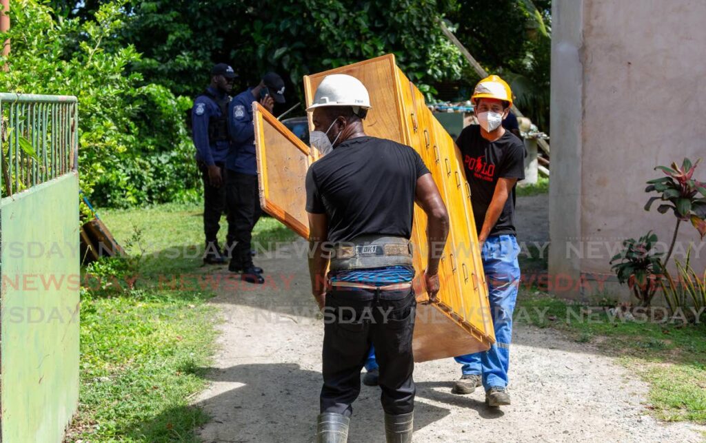 China Railway Construction employees remove furniture and other belongings from a home at Crompston Trace, Store Bay Local Road, Bon Accord Tobago on Thursday. - File photo
