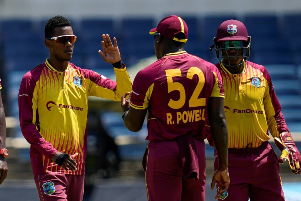 West Indies' bowler Akeal Hosein (left) celebrates with stand-in captain Rovman Powell after he bowled New Zealand's Martin Guptill during the third T20 International at Sabina Park in Kingston, Jamaica, on Sunday.  