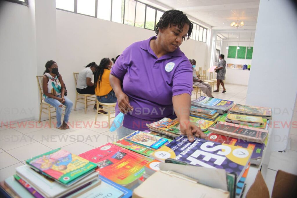 Betty Ann Byng, director of Aspiring Minds Foundation, organises books for distribution during a book drive  organised by the NGO at Gransul Street, San Fernando, last Monday. - Lincoln Holder