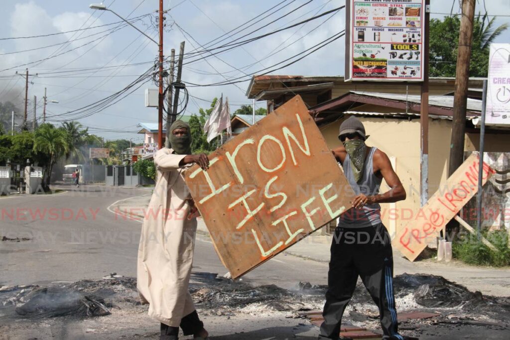These men protest the ban on scrap iron exports at Southern Main Road, Claxton Bay on Tuesday. Photo by Marvin Hamilton