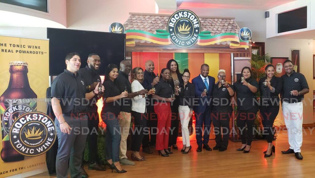 Carib Brewery officials pose for photos revealing their new product Rockstone Tonic Wine at Queen's Park Oval. - Elexzine Bissoo