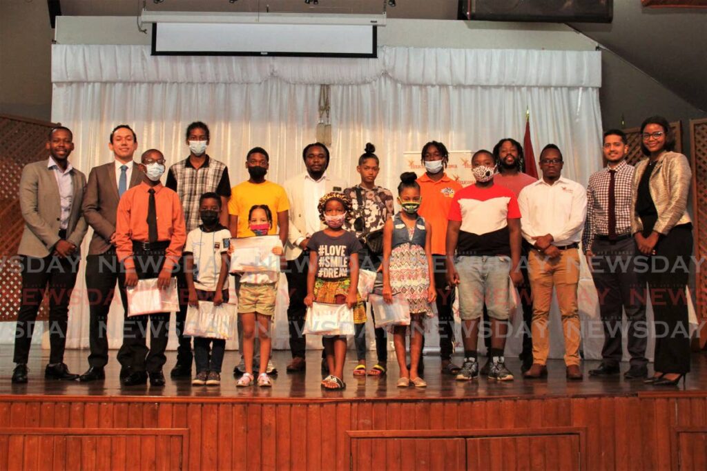 Heliconia Foundation and San Fernando City Corporation representatives with some of the students who received school supplies at the San Fernando City Hall on Friday. - Marvin Hamilton