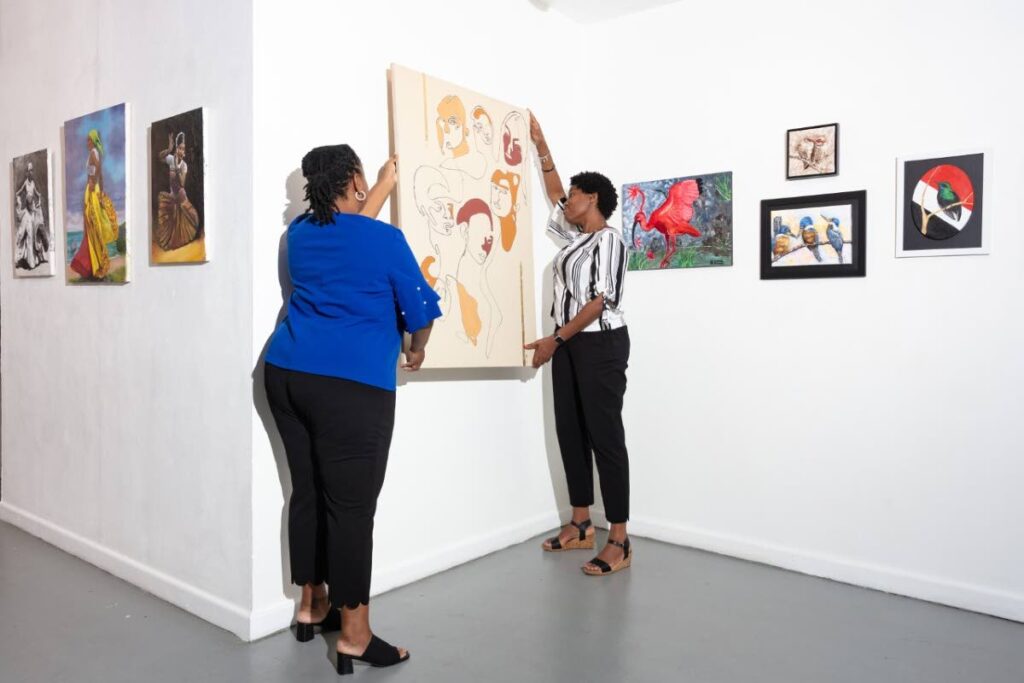 President of the Art Society of Trinidad and Tobago Keiba Jacob Mottley, right, and Chantal Quamina, secretary installing artwork for the exhibition  Independence – An Artistic Perspective. - 