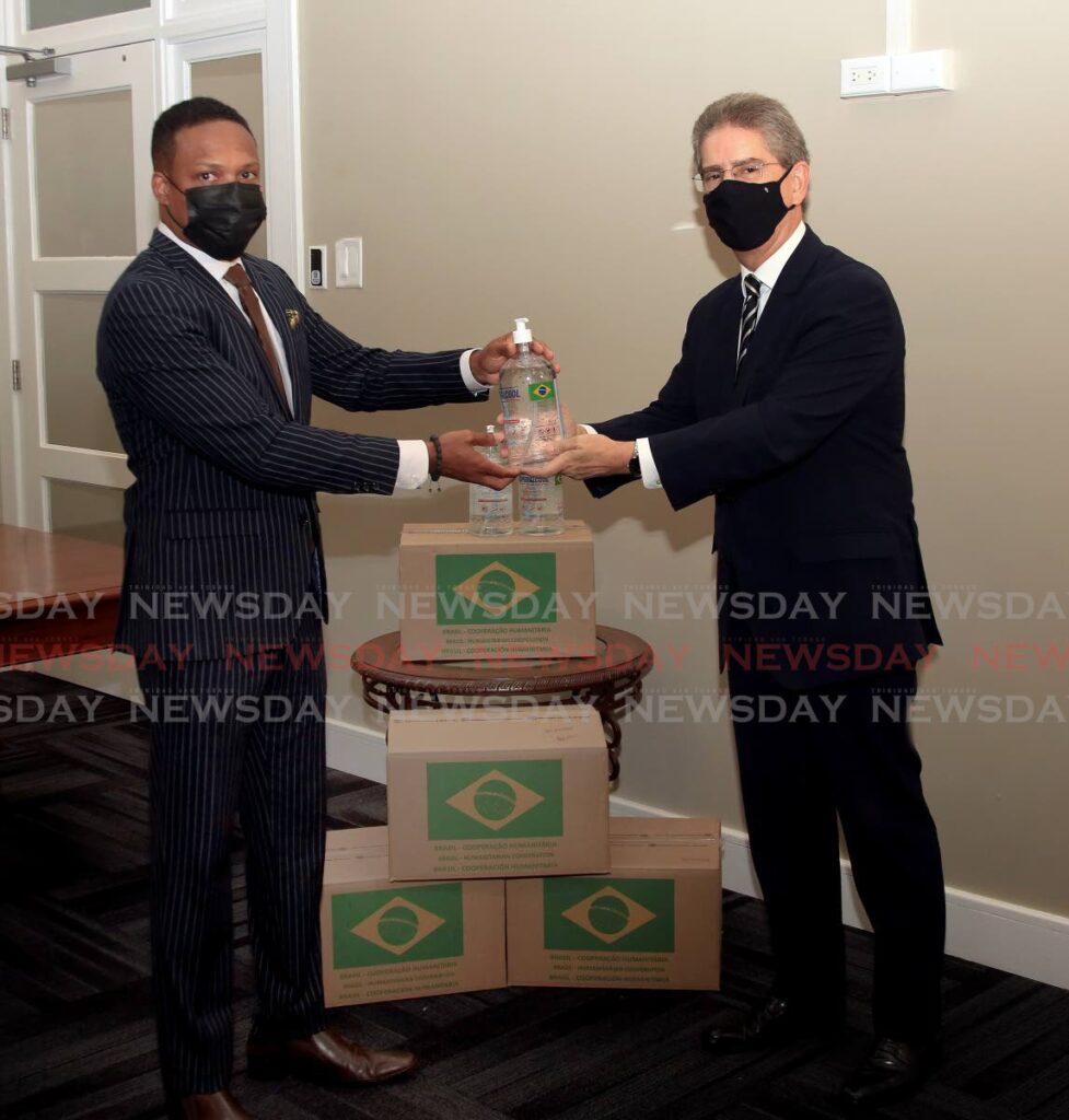 Minister of Foreign Affairs Dr Amery Browne, left, receives a portion of the 28,800 litres of hand sanitiser from the Brazil Ambassador Rodrigo Do Amaral Souza that were donated to TT by his government. - SUREASH CHOLAI