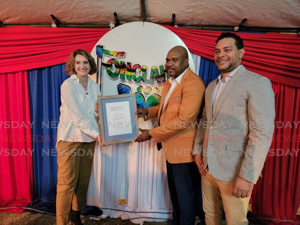 Darren Sheppard, centre, receives the Point of Stars Award from British High Commissioner Harriet Cross, left. Looking on Minister of Tourism and Culture Randall Mitchell. Photo by Yvonne Webb