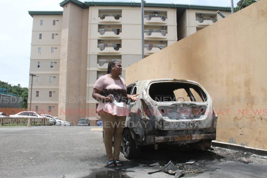 WPC Jamilla Phillip speaks to Newsday on Friday as she stands next to her car that was firebombed on Wednesday at the HDC Chaconia Crescent apartment complex, Four Roads, Diego Martin, where she lives. Photo by Ayanna Kinsale