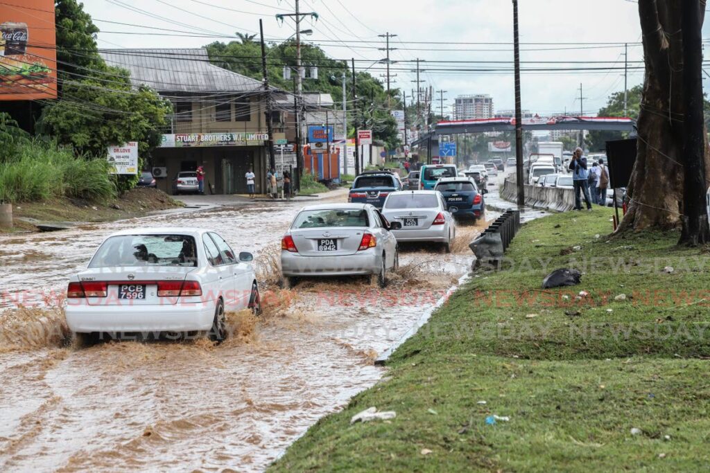 Drivers manoeuvre through floodwaters in Cocorite on Monday. Photo by Jeff K Mayers