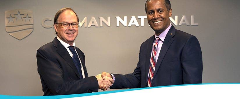  Stuart Dack, CEO of Cayman National Corporation, and Nigel Baptiste, president and CEO of Republic Financial Holdings Ltd, shake on an agreement to merge the operations Republic Bank (Cayman) Ltd with Cayman National Bank and Cayman National Securities Ltd. - 