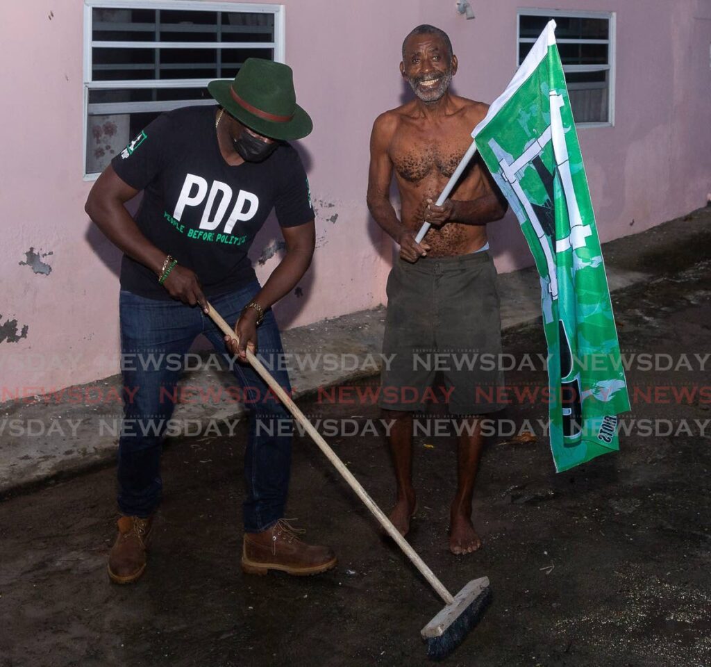 PDP political leader Watson Duke, left, takes a broom from an Argyle resident during a walkabout ahead of the last THA elections. FILE PHOTO - 