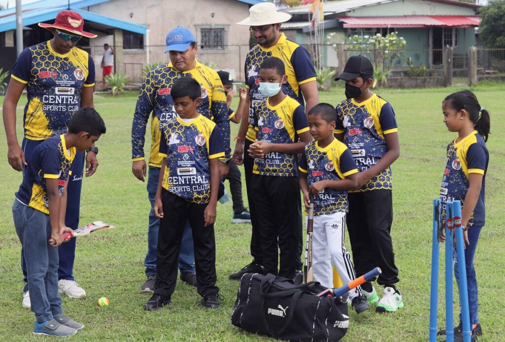 Youngsters learn the proper way to hold a cricket bat at the opening day of Central Sports Club and Chaguanas West MP Dinesh Rambally's cricket camp which bowled off at Invaders Recreation Ground, Felicity on July 2. PHOTO COURTESY CONSTITUENCY OF CHAGUANAS WEST. - 