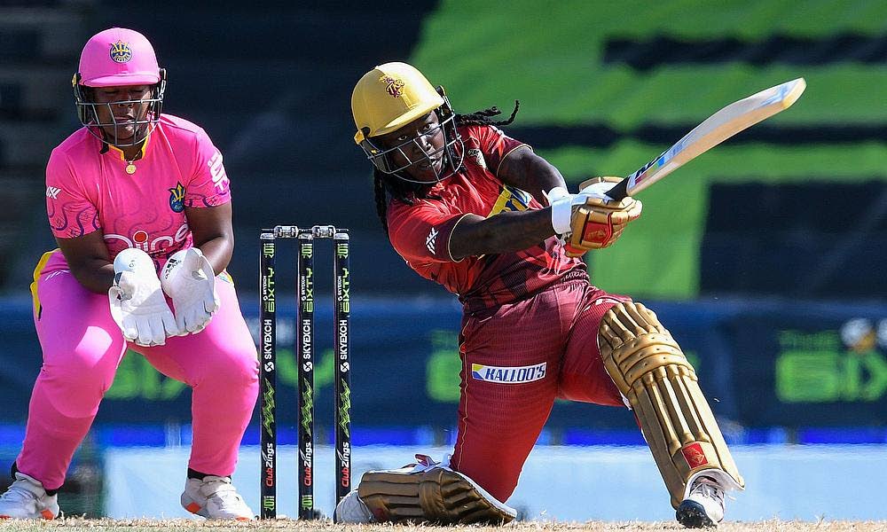 Trinbago Knight Riders women captain Deandra Dottin powers a shot through the on-side while Barbados Royals wicketkeeper Reniece Boyce looks on, during their 6ixty women match at Warner Park, Basseterre, St Kitts on August 25. Photo courtesy 6IXTY 2022. 