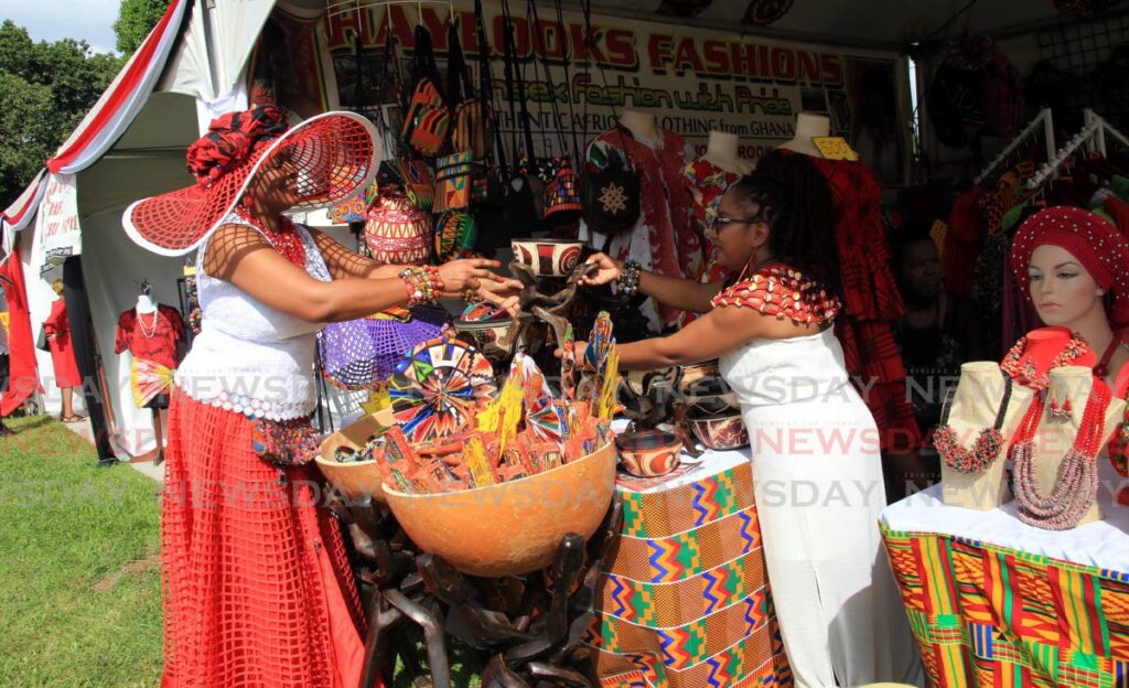 Josephine Hayford (left) attends to a customer at her booth Hay Looks at the Export Centres Company Ltd's Craft Hub at Adam Smith Square, Port of Spain, on Wednesday. - Sureash Cholai