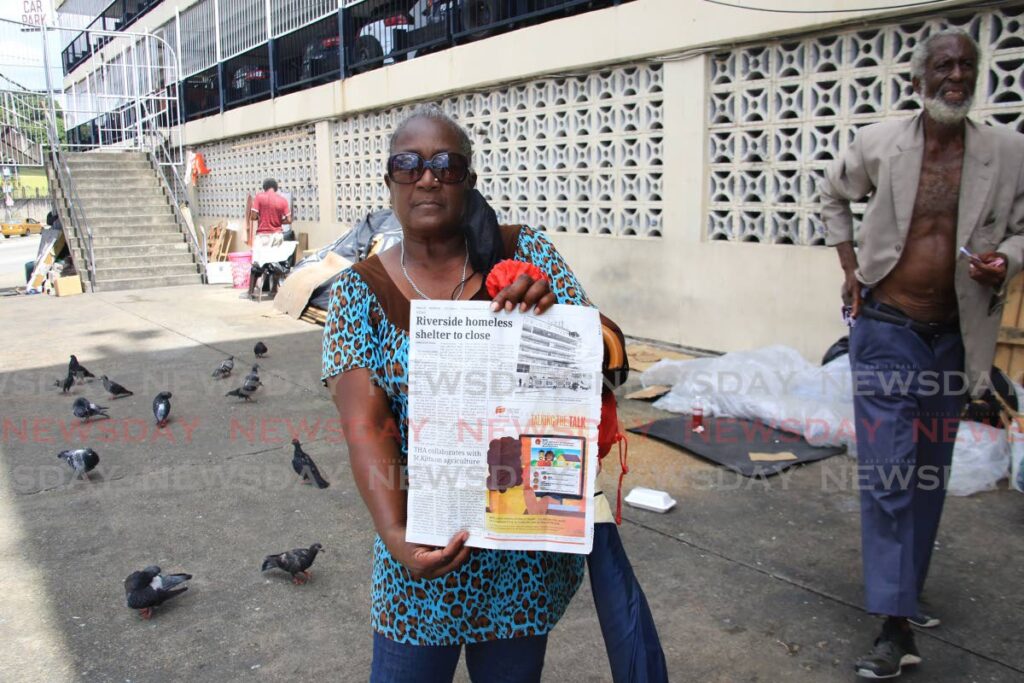 Rosita Thomas, one of the homeless people removed from the Centre for Socially Displaced Persons at Riverside Plaza in Port of Spain, shows off a Newsday clipping outside the building on Wednesday.  - SUREASH CHOLAI