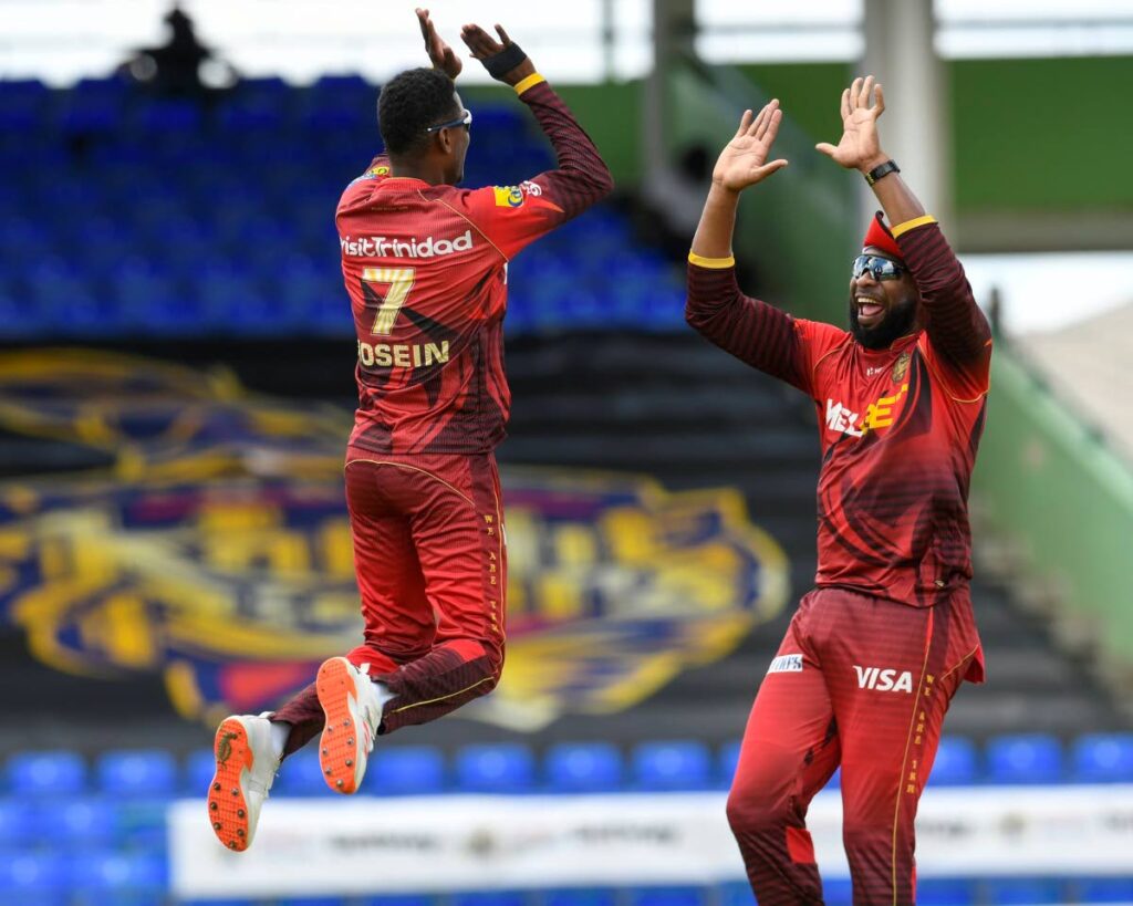 Trinbago Knight Riders captain Kieron Pollard (right) celebrates with his teammate Akeal Hosein after the fall of a wicket during their team's 2022 Hero Caribbean Premier League (CPL) match against the St Lucia Kings at Warner Park, Basseterre, St Kitts on Thursday. PHOTO COURTESY CARIBBEAN PREMIER LEAGUE. - 