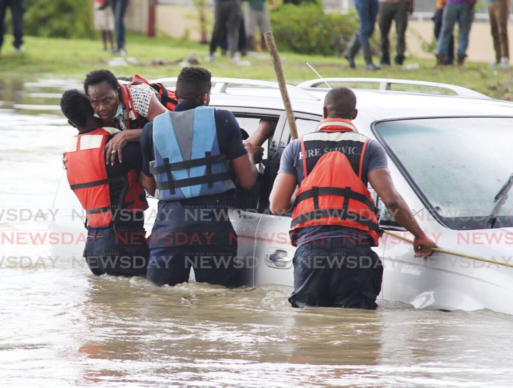 ‘THANK YOU, JESUS!’: Myrtle Benjamin is rescued from her car that stalled in rising floodwaters on the San Fernando By-pass Road near South Park on Friday afternoon. She was rescued by firemen from the Mon Repos Fire Station. - Lincoln Holder