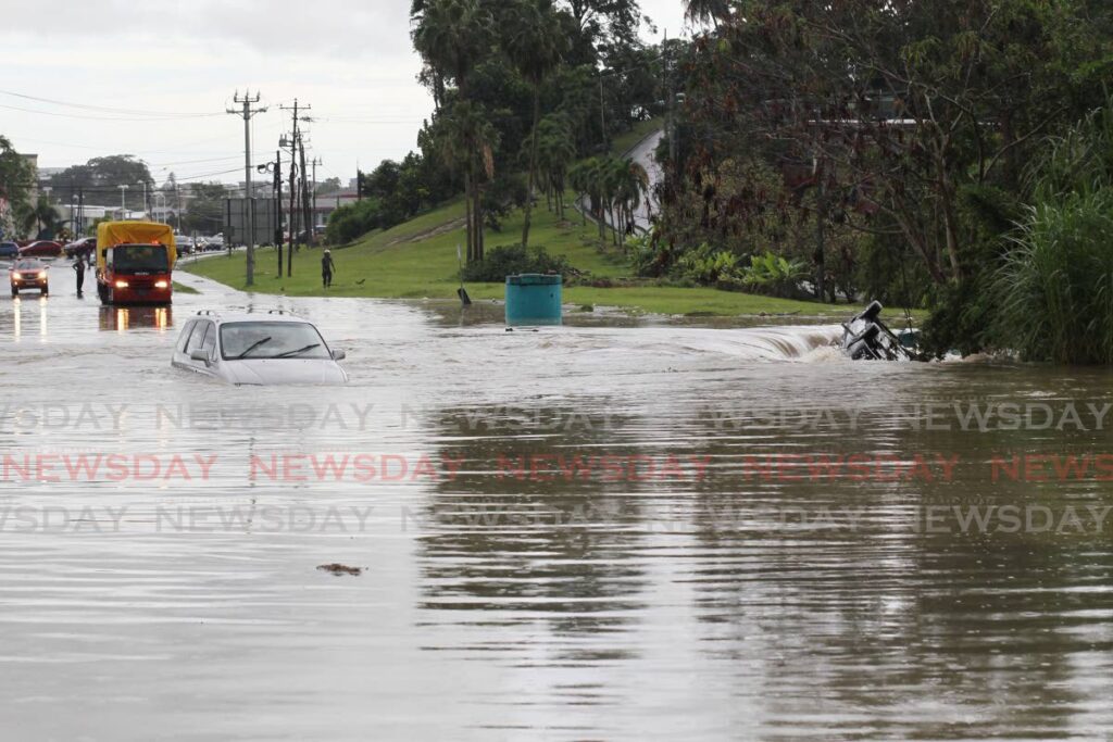 The vehicle driven by Myrtle Benjamin stalled in the middle opf flood waters along the San Fernando By-pass road, near South park. The vehicle behind her was swept away by the flood waters. - Lincoln Holder