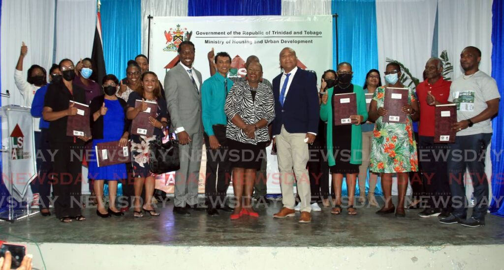 Housing and Urban Development Minister Camille Robinson-Regis with the 25 recipients of leases under her Ministry's Land Settlement Agency (LSA) progamme at a ceremony at the Chaguanas Community Centre. With her is LSA CEO Hazar Hosein, left, and Minister in the Ministry of Housing and Urban Development Adrian Leonce and on right is LSA's Chairman, Wayne Inniss.  Photo by Sureash Cholai