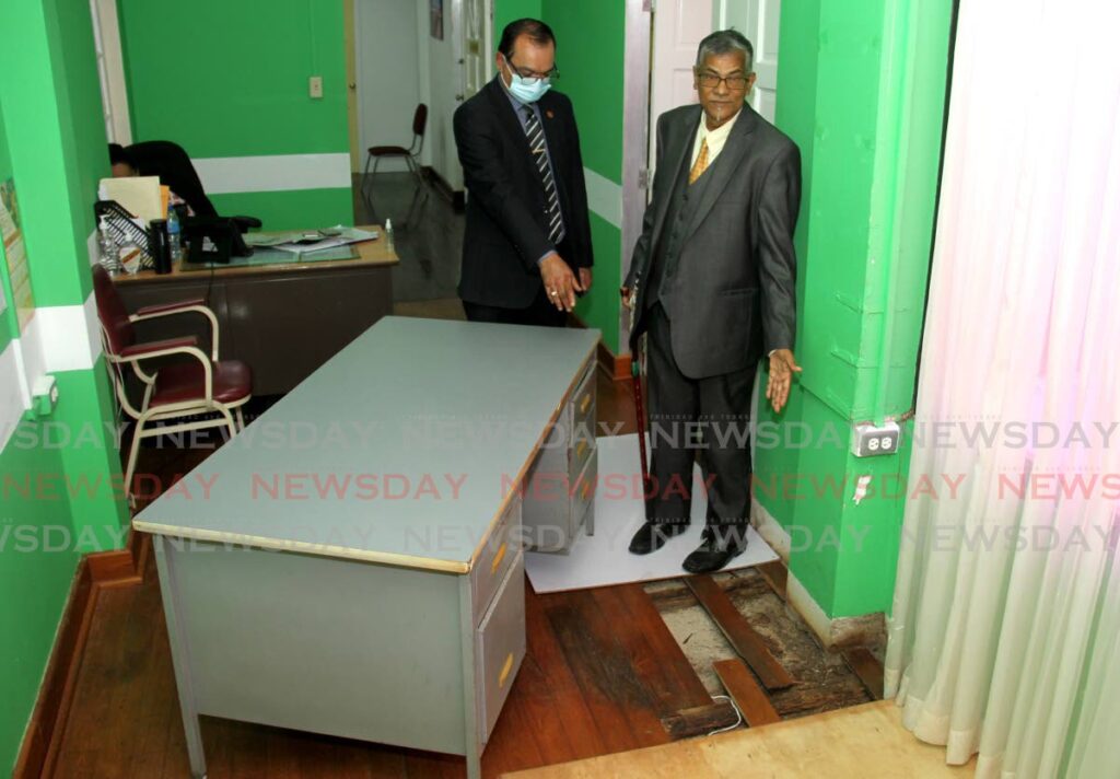 Cedros councillor Shankar Teelucksingh, left, and  Siparia Regional Corporation chairman Denish Sankersingh  points to the damaged floor at their office at the Siparia Regional Corporation, High Street, Siparia on Wednesday.  Photo by Ayanna Kinsale
