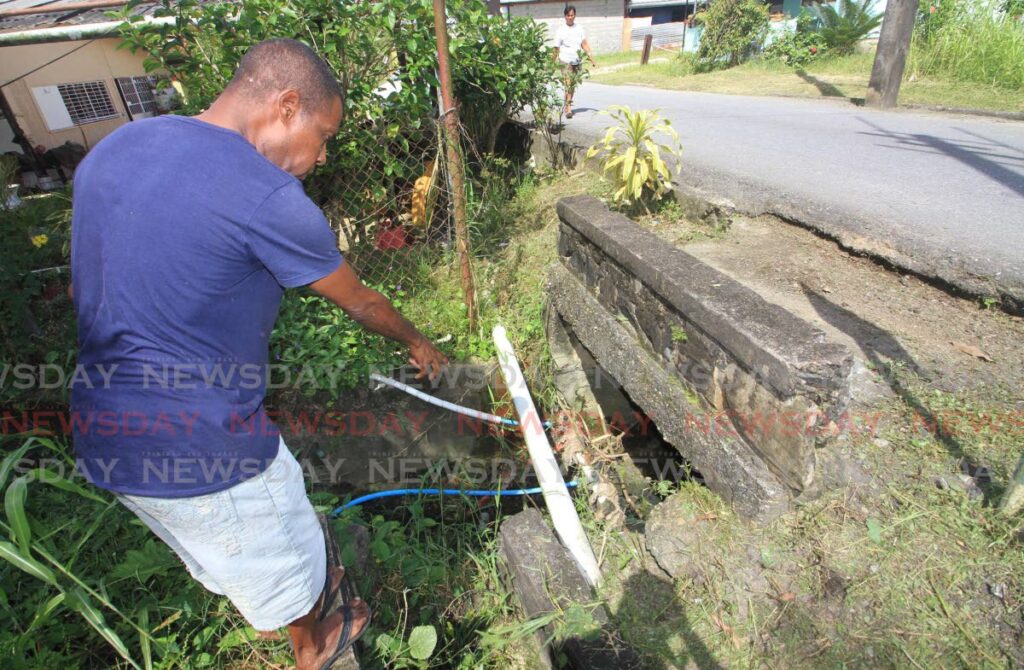 George Le Blanc points to a leaking water line at Sesame Street, Pinto Road, Arima. Photo by Aneglo Marcelle 