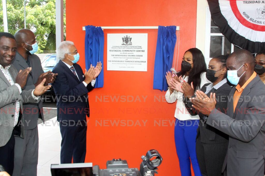 (centre) Minister of Sports and Community Developmen Shamfa Cudjoe and Minister of Health Terrence Deyalsingh unveil the plaque during the opening of the Maitagual Community Centre, Bushe Street in San Juan. -Photo by Roger Jacob