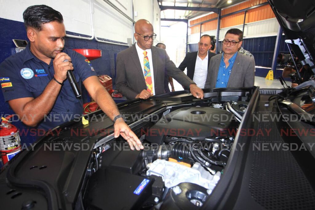 From right, President, Greater San Fernando Area Chamber of Commerce, Kiran Singh, Massy Motors Senior Vice-President Jean-Pierre duCoudary and San Fernando Mayor Junia Regrello, looks on as Massy Motors Lead Technician Randal Ramdass explains the engine of a Volvo XC90 vehicle, at the launch of Massy Motors, Gulf View, San Fernando branch on Thursday. Photo by Angelo Marcelle