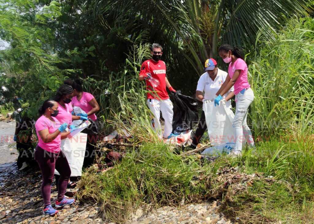 Minister for Planning and Development Pennelope Beckles, second from right, Ambassador of Venezuela Alvaro Cordero, third from right, and students from Bishop Anstey High School East remove rubbish from the foreshore, Cocorite, to mark International Coastal Clean-Up Day.  -SUREASH CHOLAI