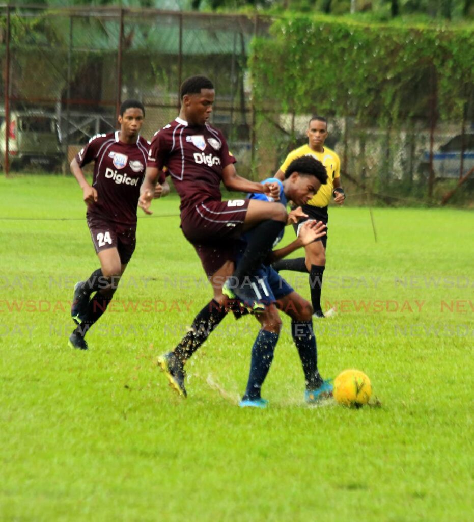 Khufu Mohammed (centre) of East Mucurapo tries to get the ball from QRC's Micah Nelson during their teams' match on Saturday, at the QRC Ground, St Clair, in the Secondary Schools Football League. Photo by Sureash Cholai